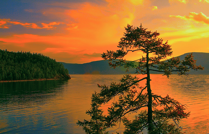 Aerial view of Khovsgol Lake with forested shoreline and boat in Mongolia