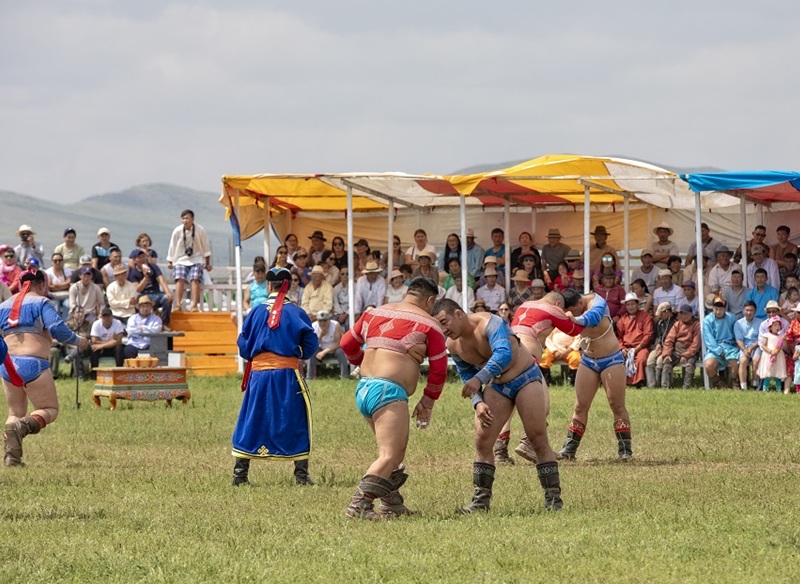 Mongolian wrestling at local Naadam Festival with spectators